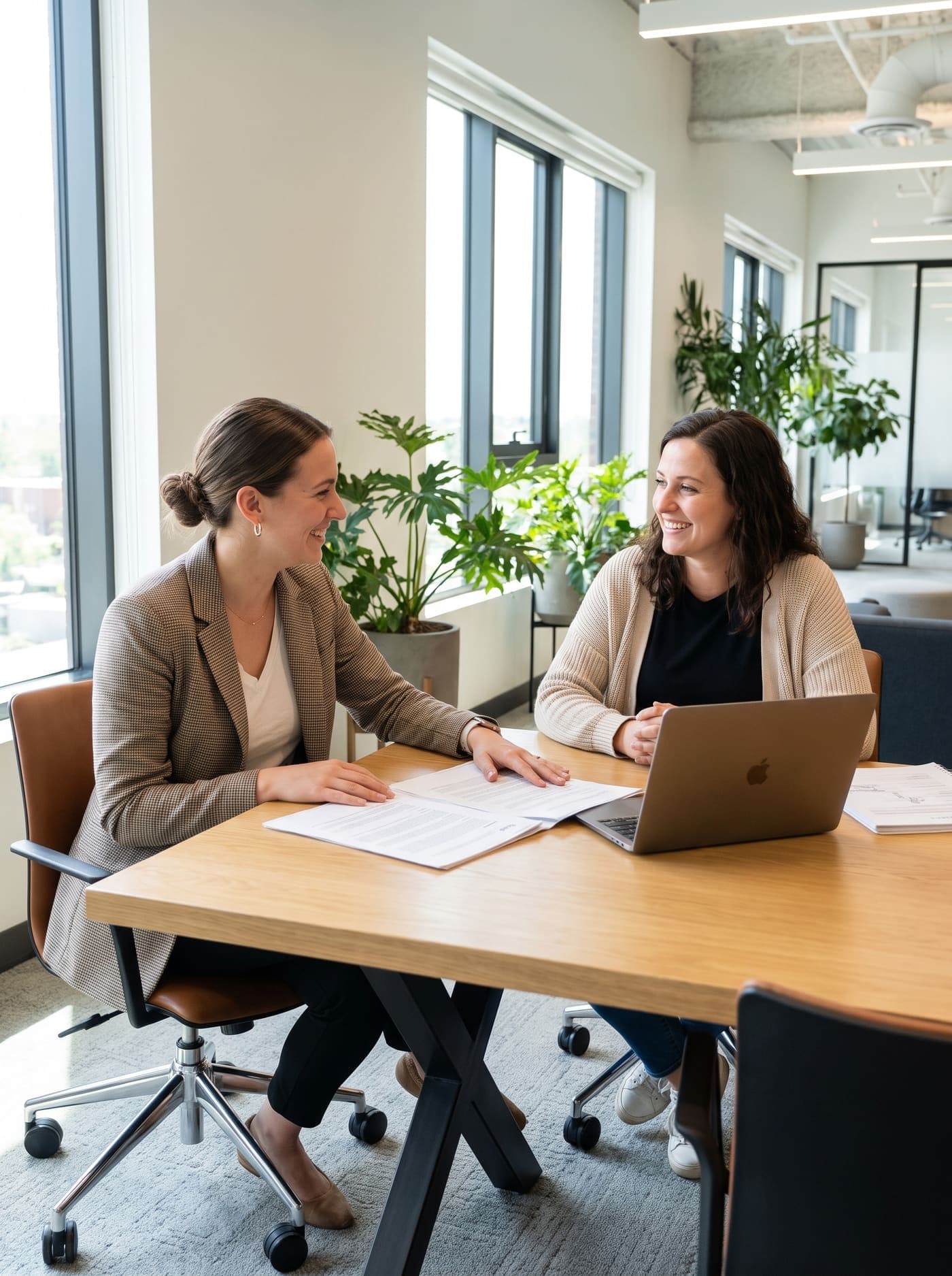 A social worker and an adult daughter discussing care options in a warm office setting